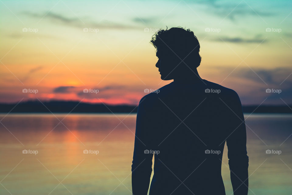 Silhouette of a Man in front of Lake with Beautiful Soft Sunset