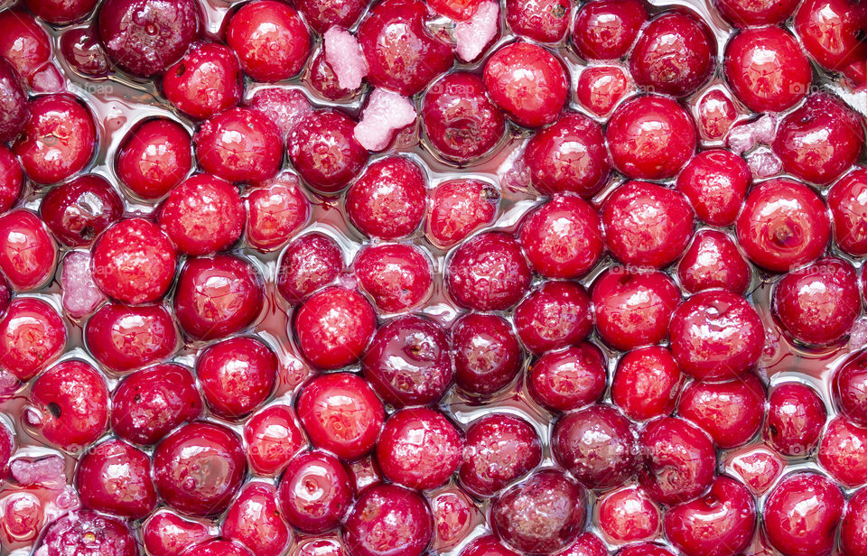 background of Cherry jam. Close up of simmering homemade cherry jam. Cherry and sugar crystal.