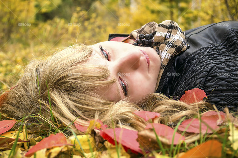 Teenager girl lying on autumn leaves