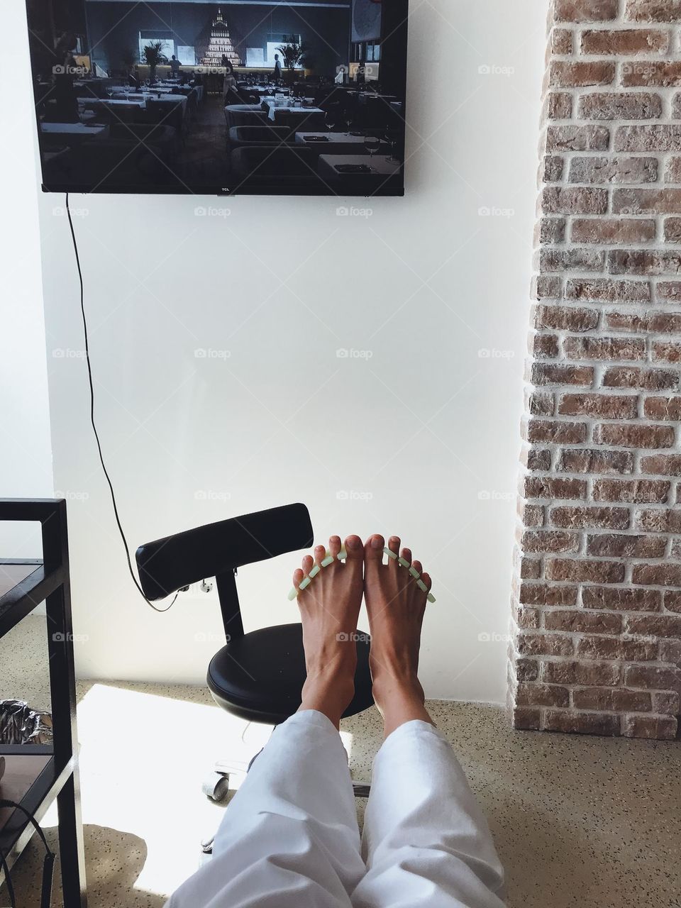 Anonymous female feet on pedicure in beauty salon 