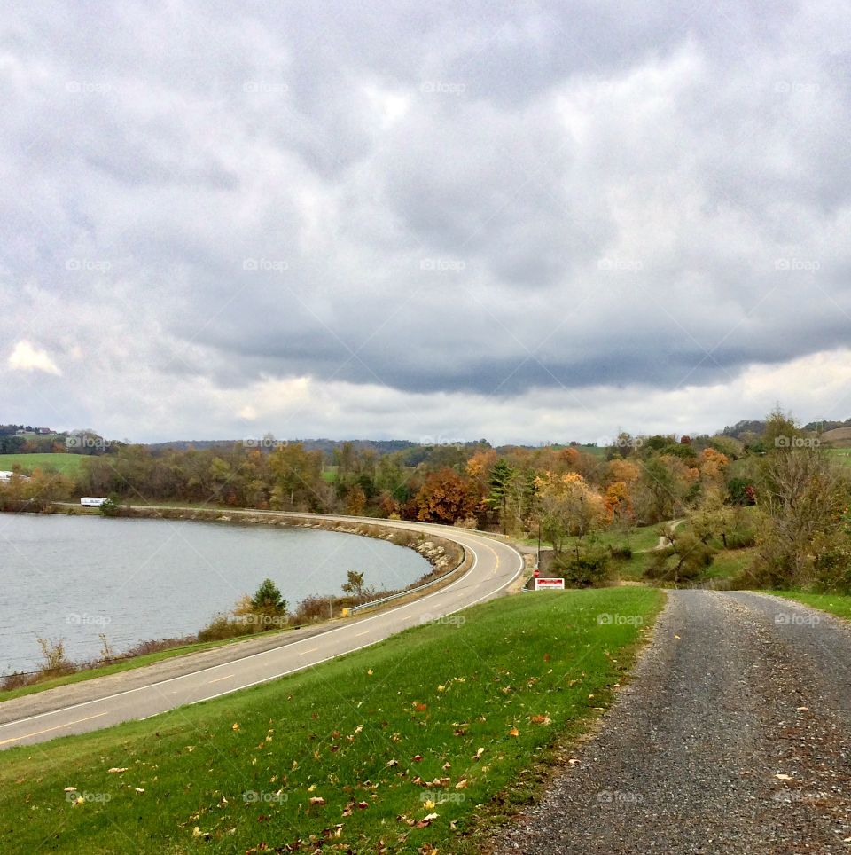 Cloudy fall day, country road beside a lake 