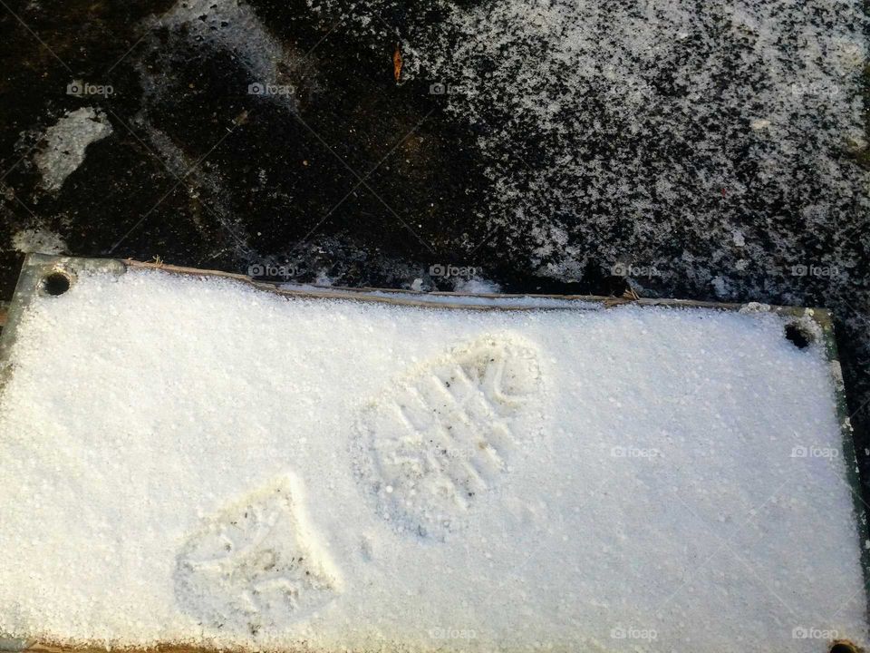 footprint on a snow covered stone slab