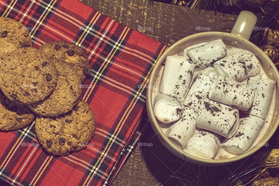 Hot chocolate and marshmallows with Christmas cookies on a tartan napkin 