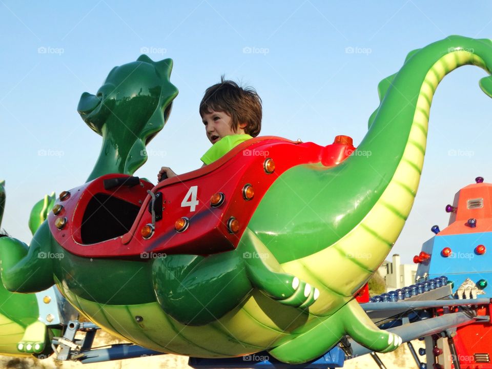 Young Boy On Amusement Park Ride
