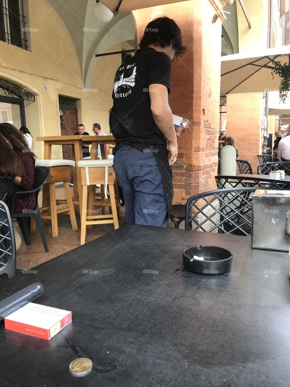 the waiter serves guests on the terrace of the bar, coffee time 