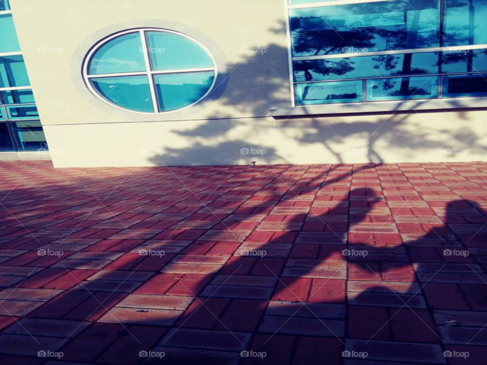 the shadow of a mother who is trying  to hold the back of her daughter  to support her.