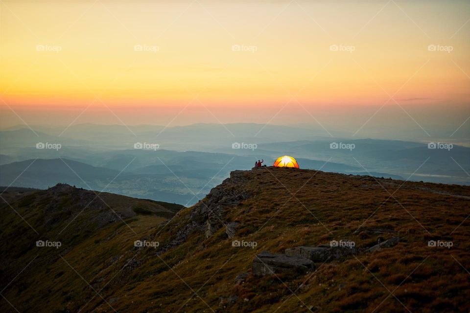 Scenic view of mountain peaks. Panoramic view. Natural scenery. Beautiful background. Natural mountain landscape. Misty peaks and foggy valleys. Orange yellow sky while sunrise. Amazing scene from Beskid Zywiecki in Poland