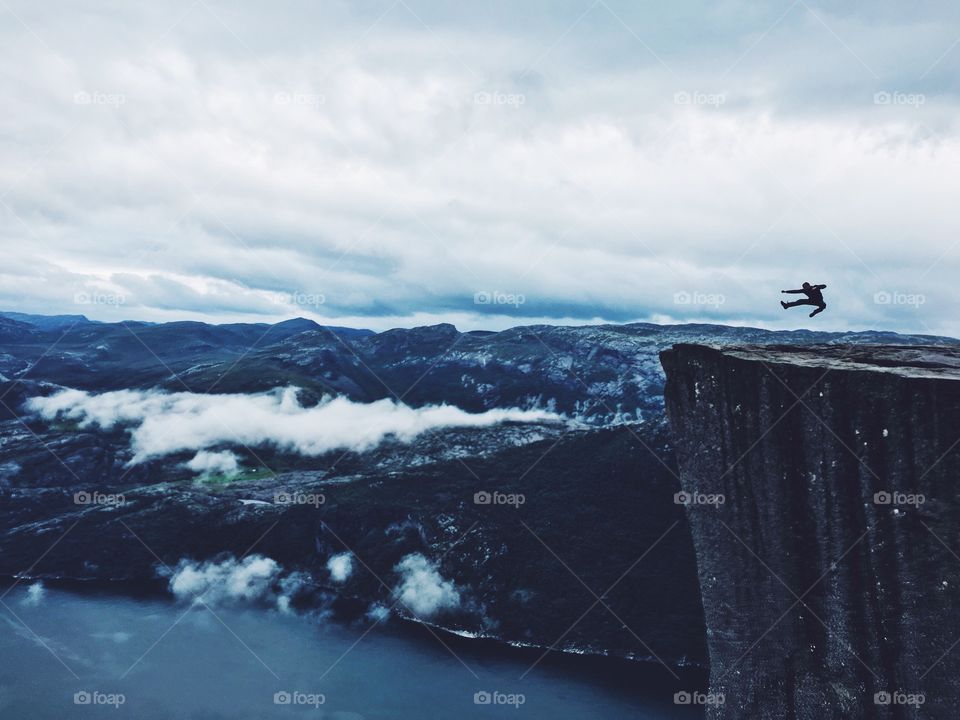 Person jumping on cliff