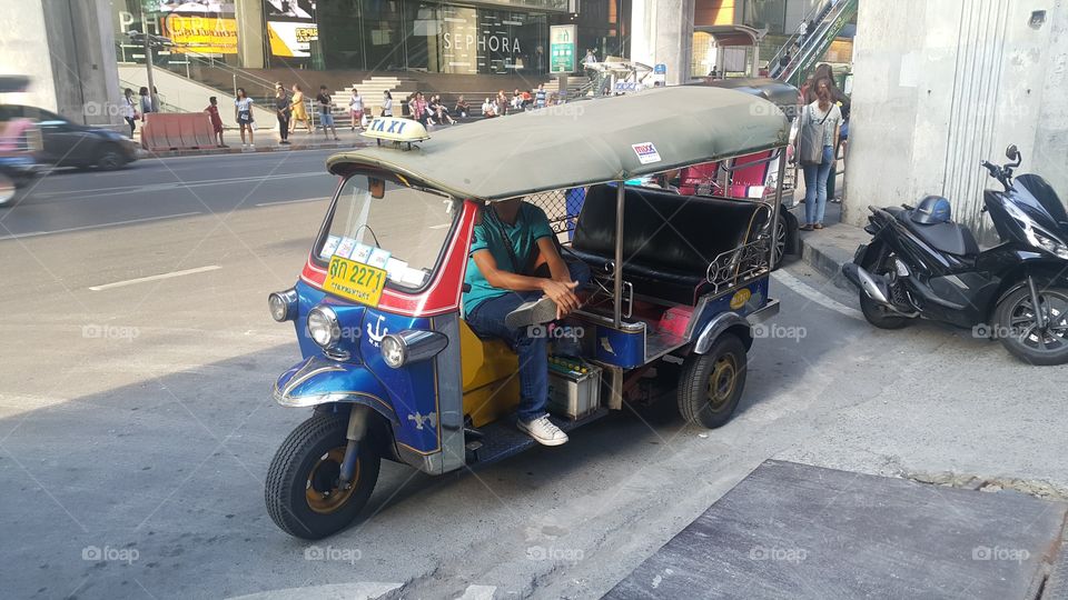 A tuk tuk taxi driver waiting passengers in bangkok ,Thailand.