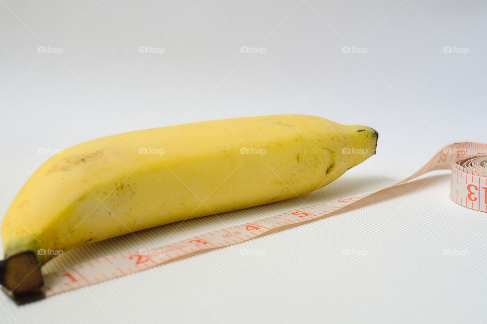 Penis size concept using banana, soft measuring tape