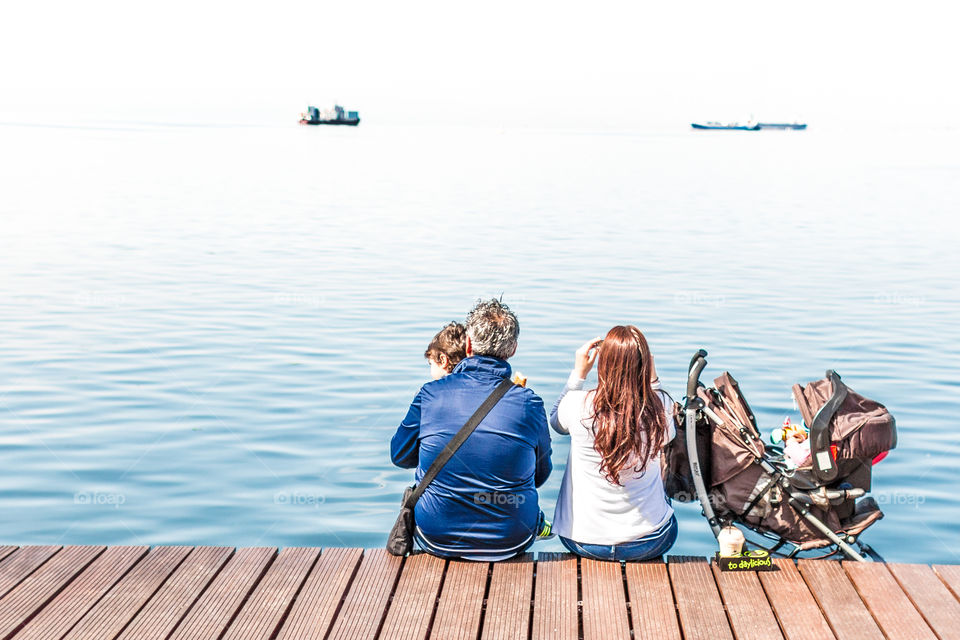 Family Enjoying The View Sitting On The Dock
