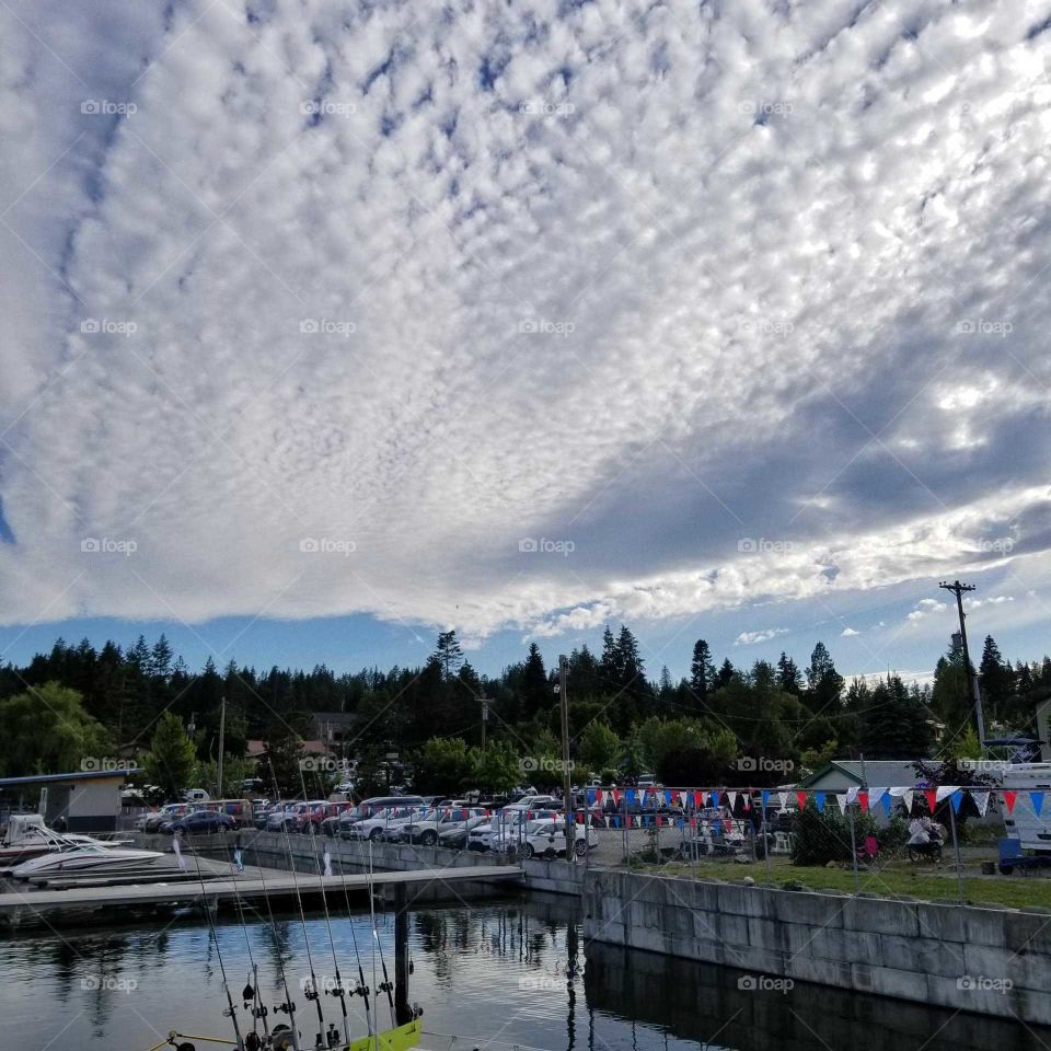 a sheen of clouds in the sky over a marina with a hint of blue sky