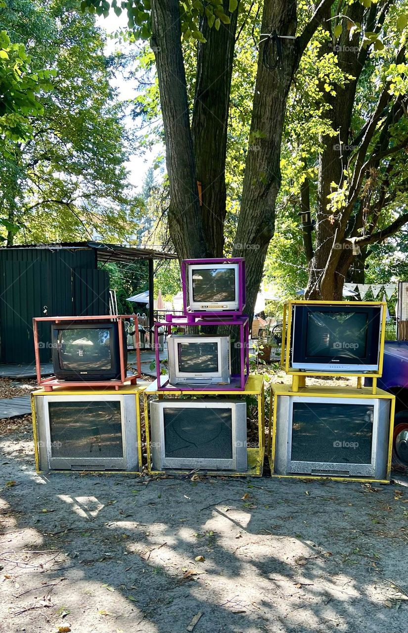 Old TVs on the street on colorful shelves