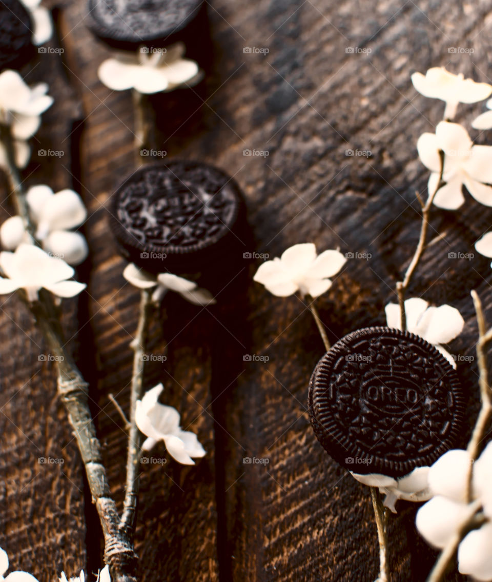 Classic Oreo Cookie Art Photography contrast on vintage rustic wood background traditional concept of spring cherry blossoms flowers with Oreo cookies on branches