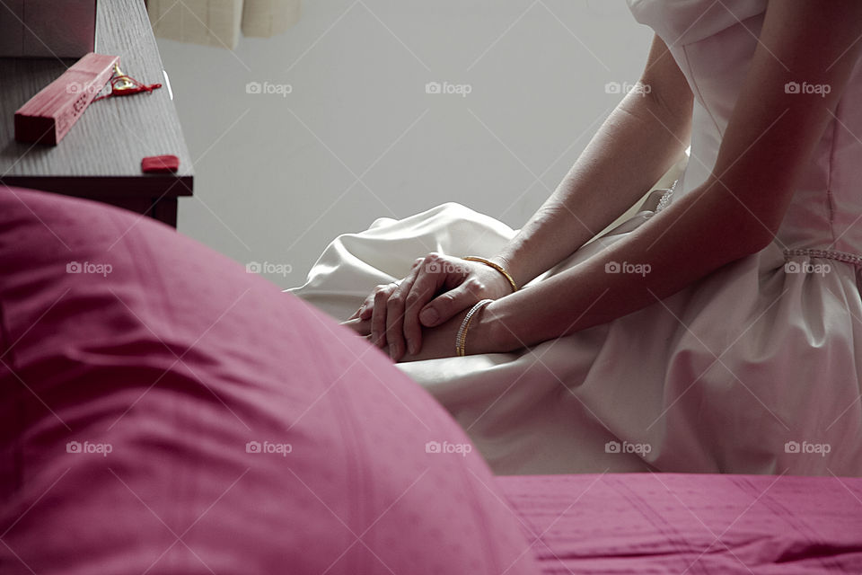 Midsection of women sitting on bed