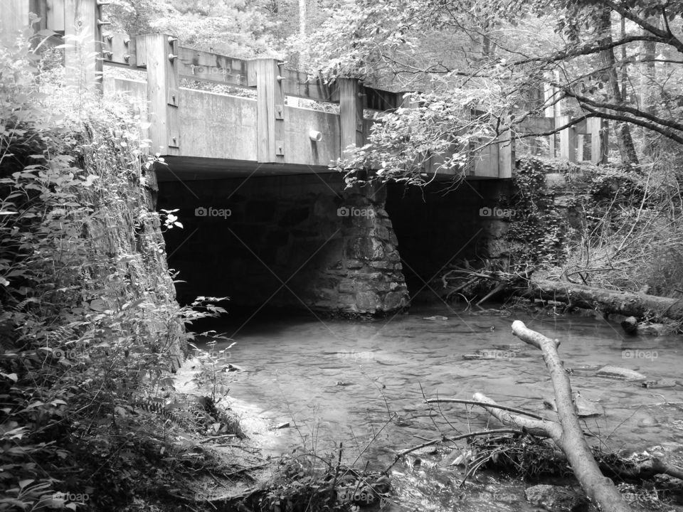 Black and white photo of a stone based bridge over a Georgia mountain stream.