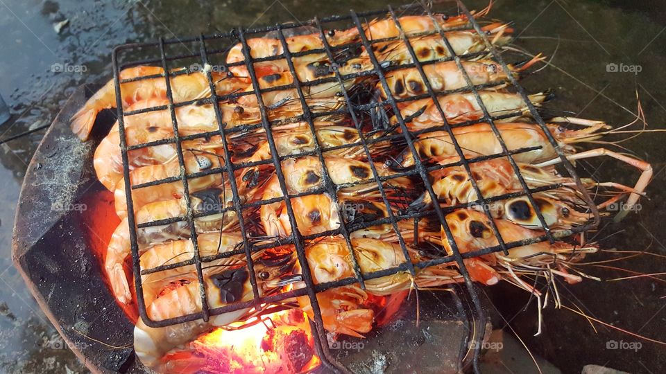 Medium well barbecue river shrimps on burning charcoal stove ready for eating