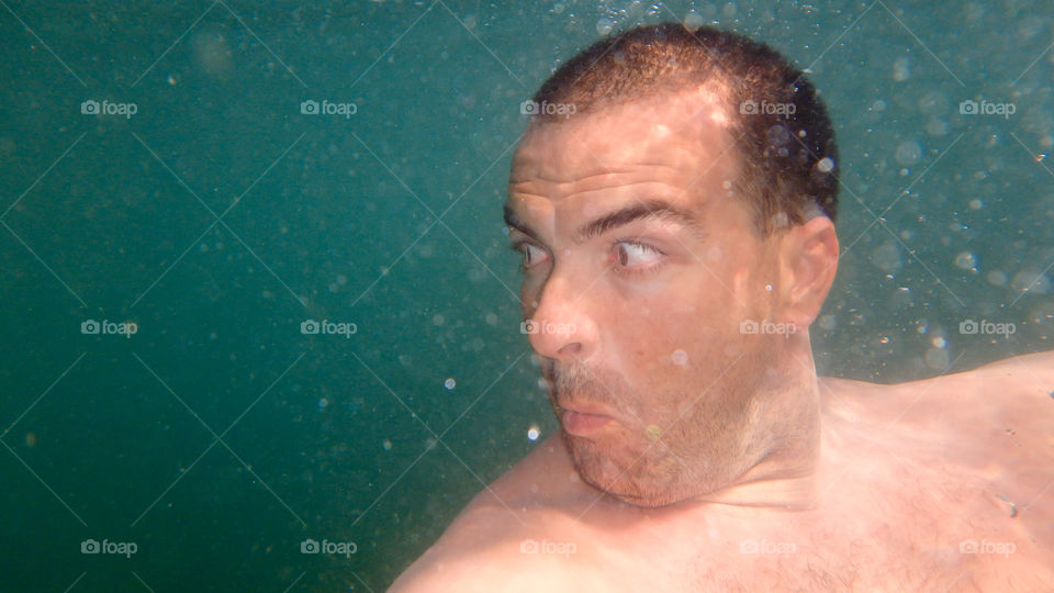 young man diving and swimming underwater