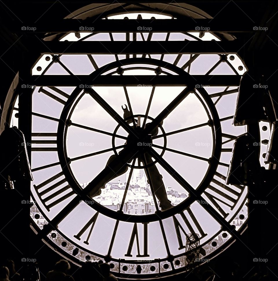 Sepia close-up shot of the old clock of Quai d'Orsay's museum with a view on Paris