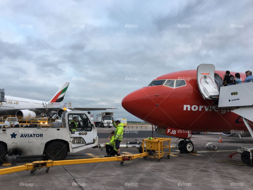 Airport staff hooking up the plane to pull the aircraft onto the runway ready for takeoff ... at least that’s what I think 