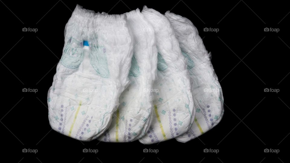 Baby diapers stacked each other on isolated background.