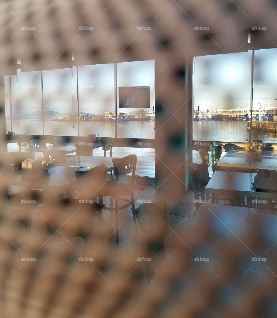 a closed restaraunt on the water of Istanbul Turkey,  taken through metal screen door