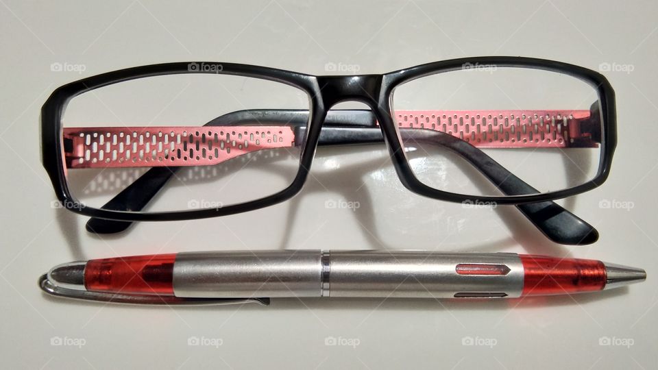 Black spectacles with imported pen with white background