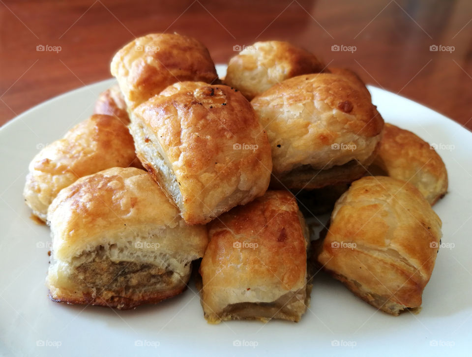 Sausage rolls in a white plate.
