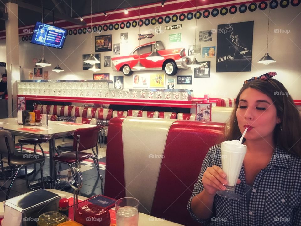 Enjoying milkshake at 1950s diner