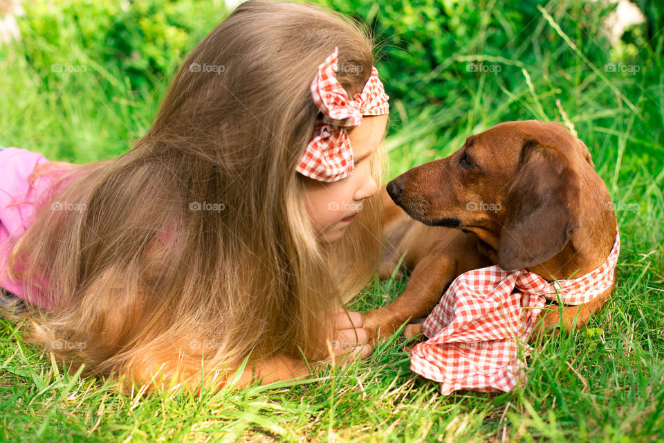 Close-up of girl lying on grass with her dog