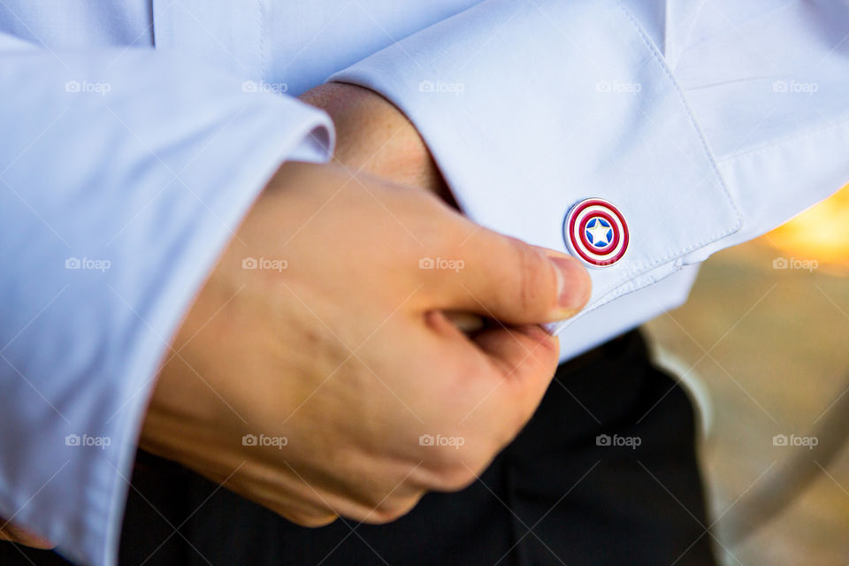 Closeup of suoerhero captain America cufflink and hands with shirt