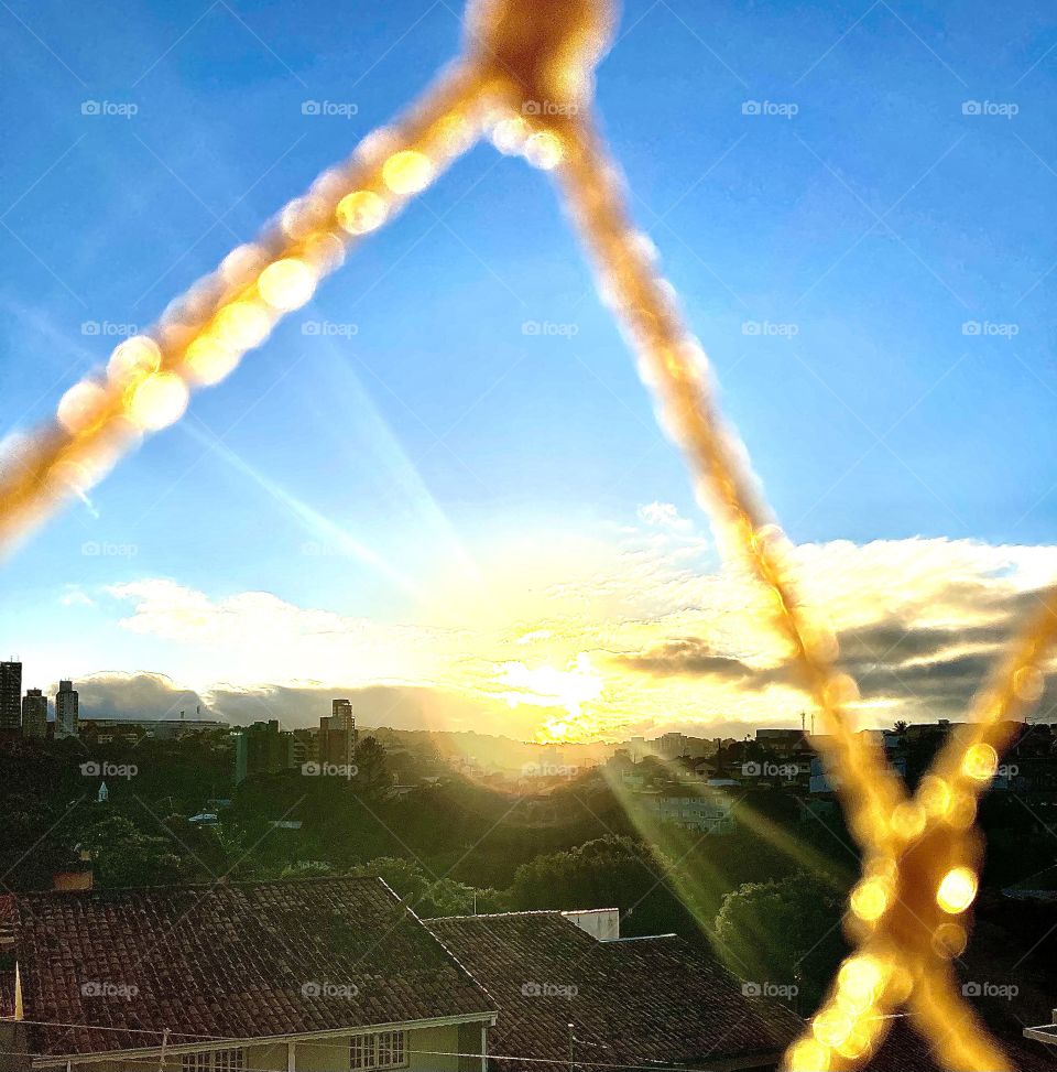 From the balcony of my house, between the window screen and the sky, I see the luminous circle of the radiant sun! / Da sacada da minha casa, entre a tela da janela e o céu, vejo o círculo luminoso do sol radiante!