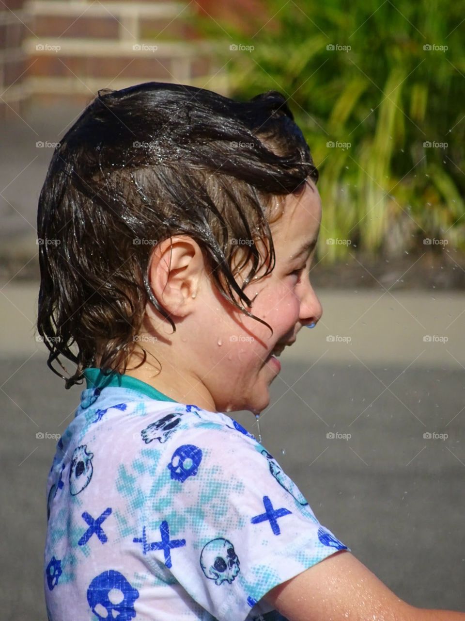 closeup of a young boy enjoying water play and happy being soaking wet