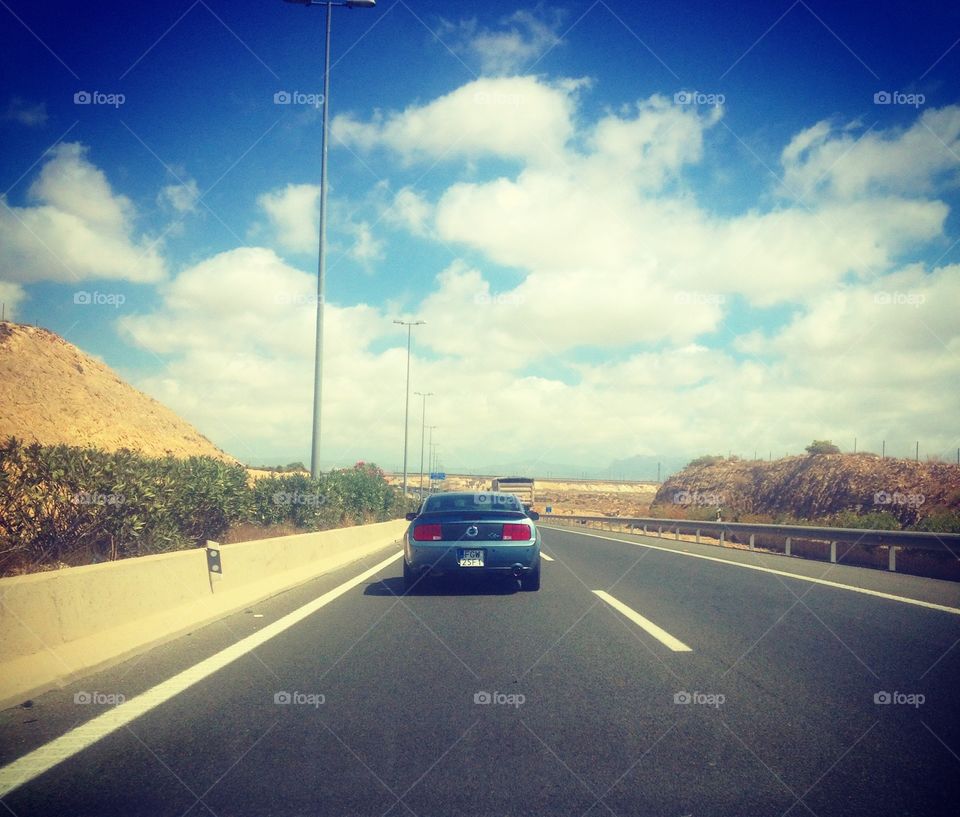 Blue mustang going trough highway in Spain