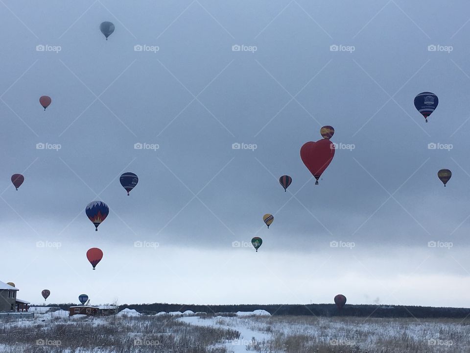 Bright balloons during a winter morning in Moscow region, contrasting with grey sky