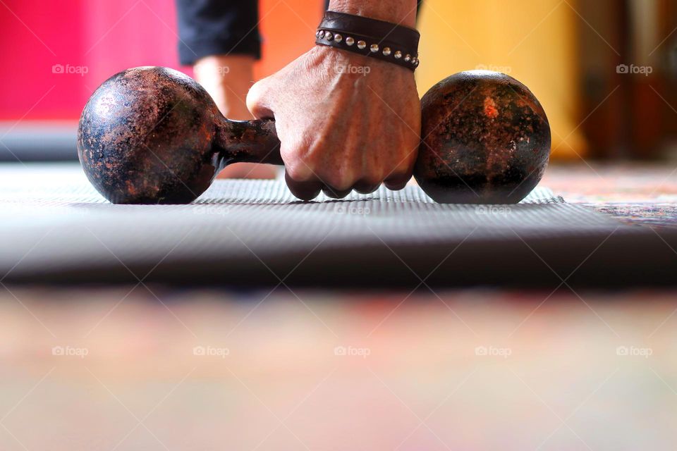 Close-up of a woman's hand holding a rusty dumbbell