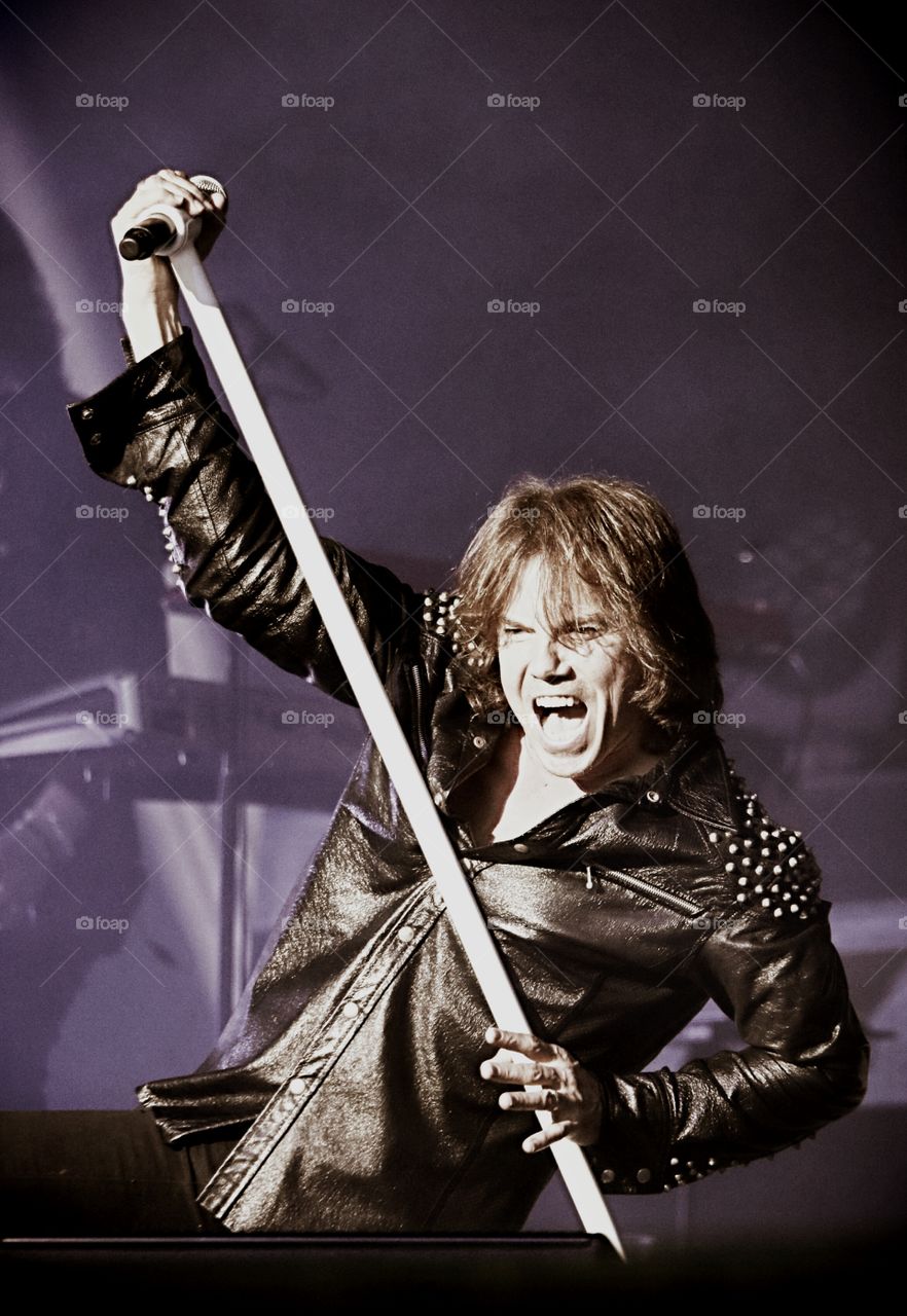 Man singing on stage holding mic in hand