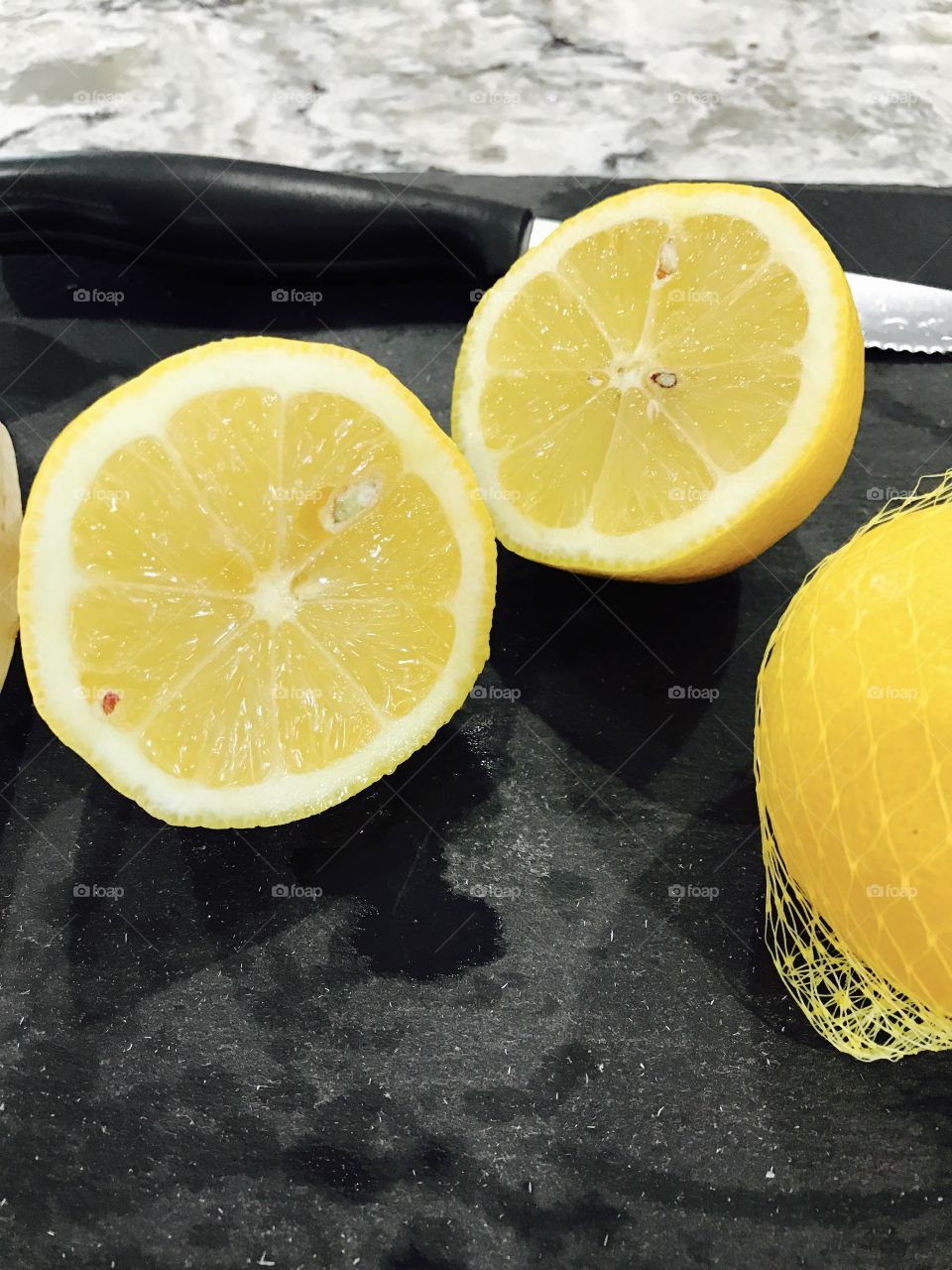 Cut yellow lemon on slate tray