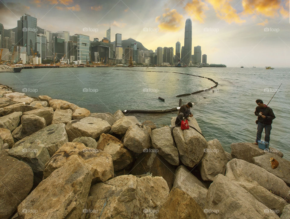 Fishing at Wan Chai. Fishermen and cats look for fish