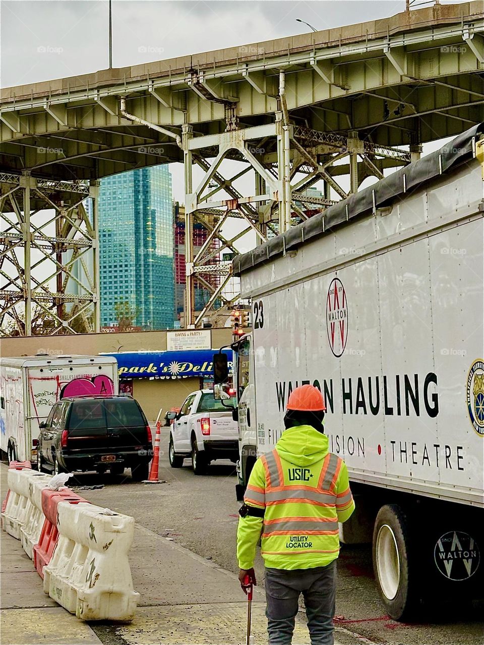 This is “Review Avenue” at the intersection of “Borden Avenue” in LIC, Queens. The multifaceted metal structure of the “Brooklyn Queens Expressway” is right ahead across the street. 2023. Hypnotic Productions