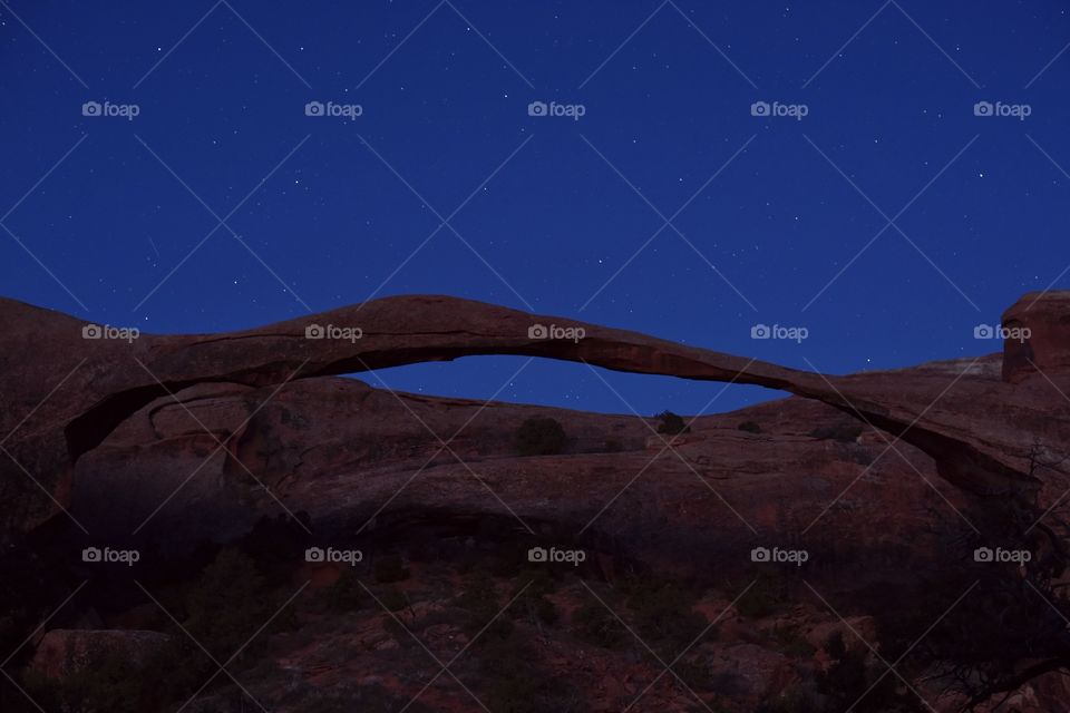 Arches National Park during dawn on a spring morning. Natural features and red slickrock make this scene surreal. Stars in a blue sky add something extra. 1