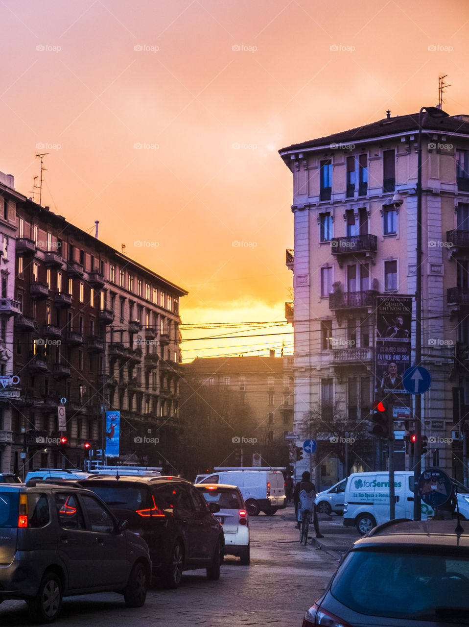 Milano center sunset. Traditional buildings, traffic, colorful, orange, yellow, blue, grey, violet, sun, sun reflection, clouds, Milano Metropolitan City, Lombardy, Italy