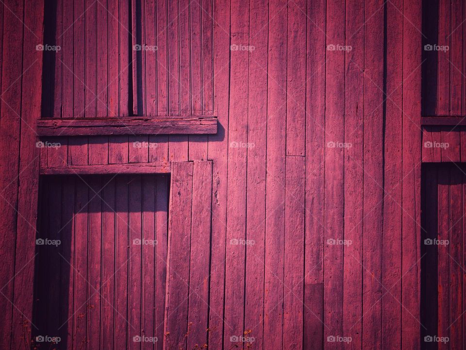 Part of a wooden door from a shipyard, magenta ish color. Wooden shelves, pink red magenta color