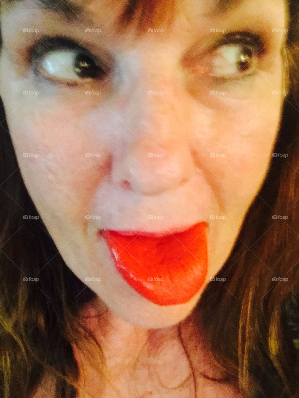 Lady sticking out her red popsickle  tongue. 