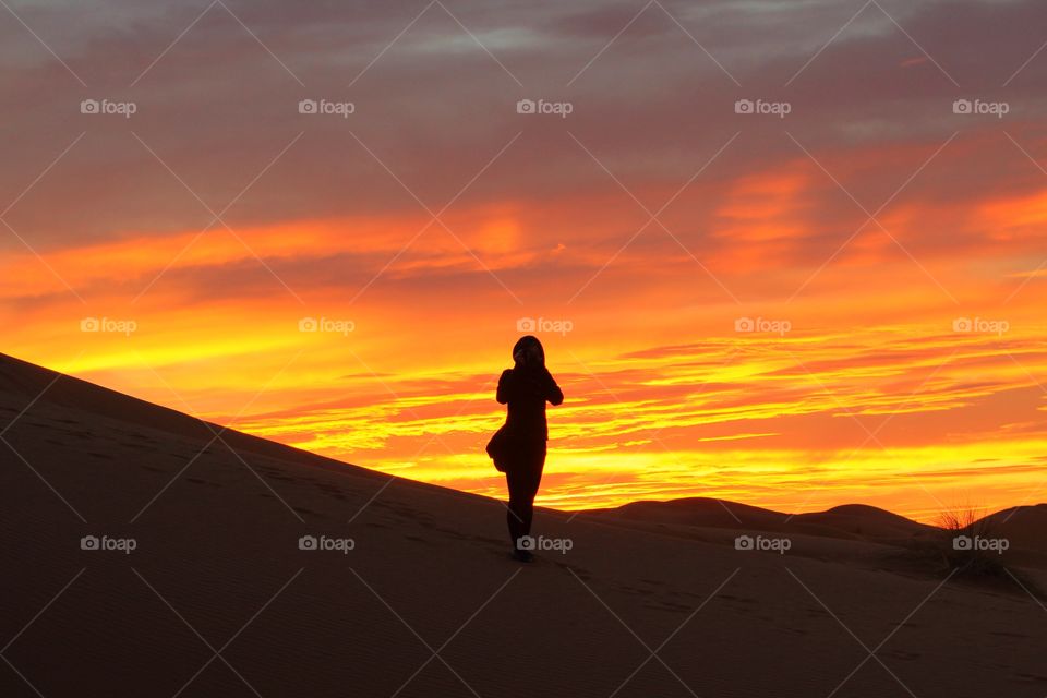 Girl watching sunrise in the Sahara 