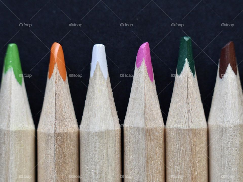 coloring pencils made of wood on a black background 
