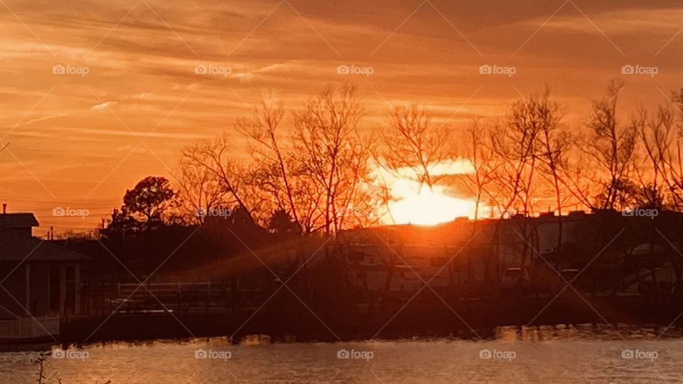 Sunset next few minutes high clouds masking the sunset. Reflections from backlit cascade on lake waters. 
