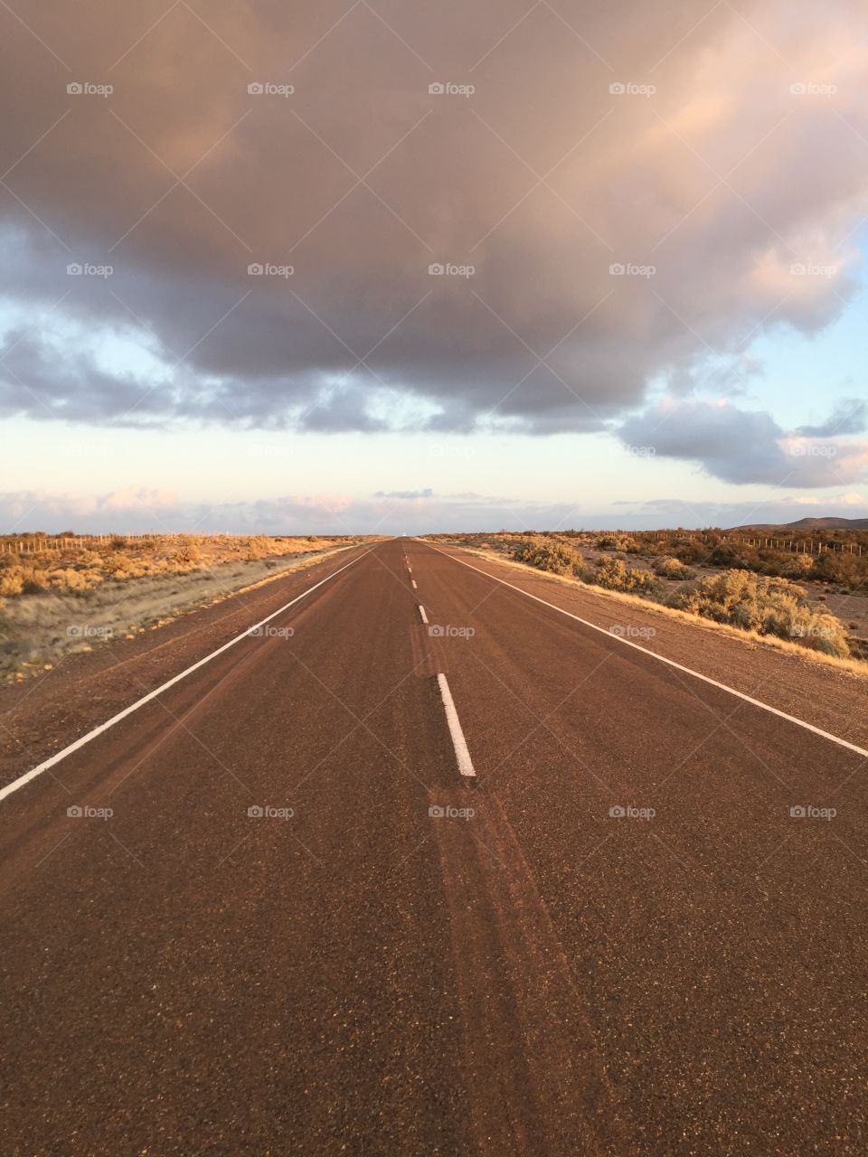 Empty road against cloudy sky
