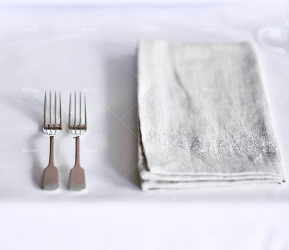 Fork and linen napkin on white table 