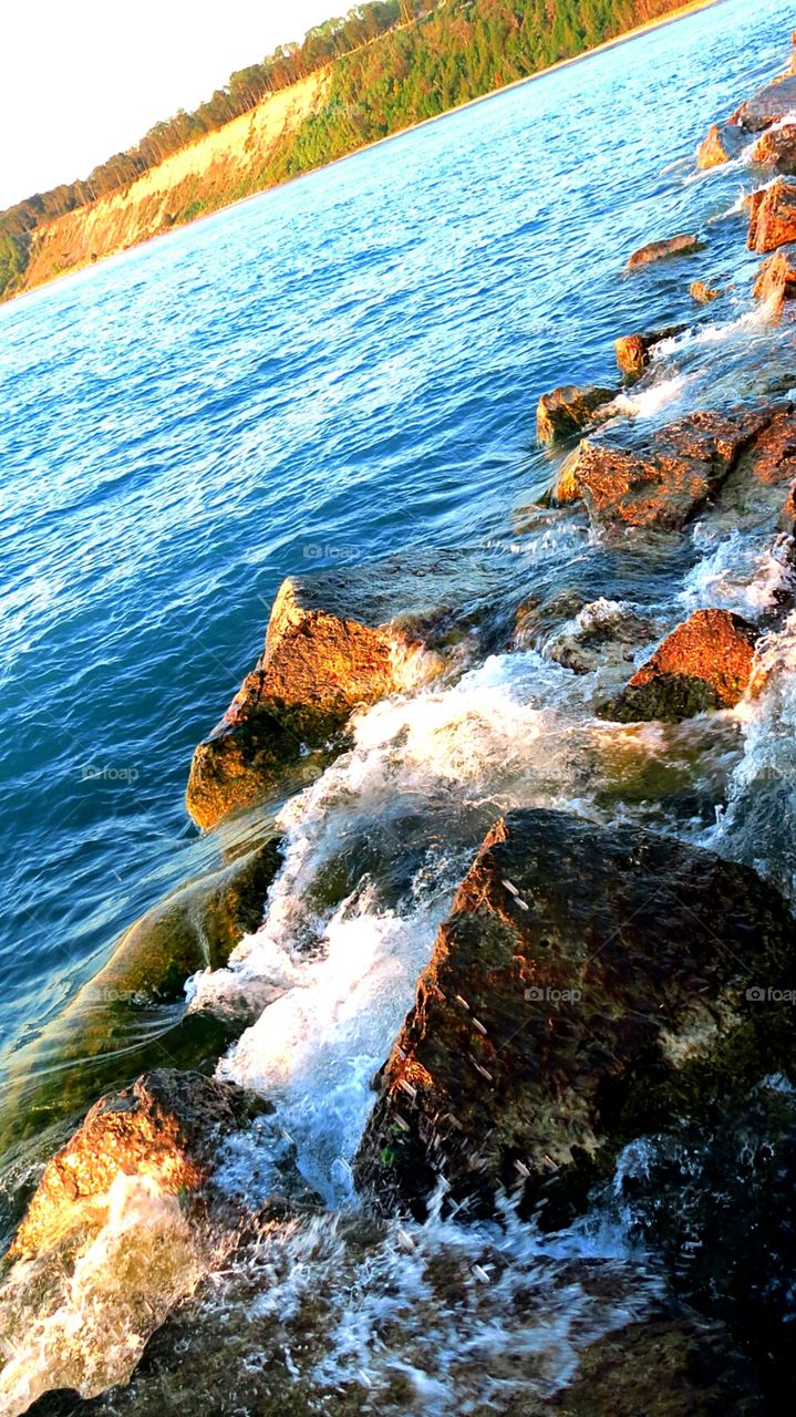 Waves crashing into rock barrier along Pier